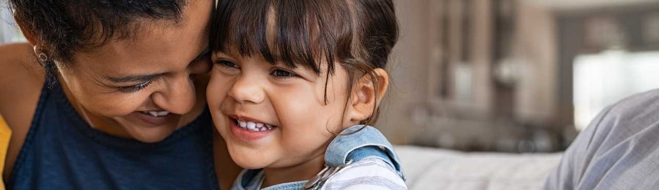 Mixed Race Mother And Daughter Huging Smiling